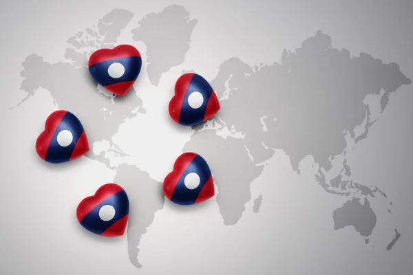 Cinque cuori con bandiera nazionale del Laos su sfondo mappa del mondo . — Foto Stock