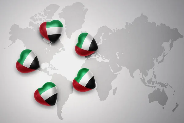 Five hearts with national flag of united arab emirates on a world map background. — Stock Photo, Image