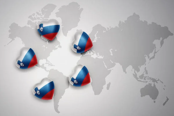 Five hearts with national flag of slovenia on a world map background. — Stock Photo, Image