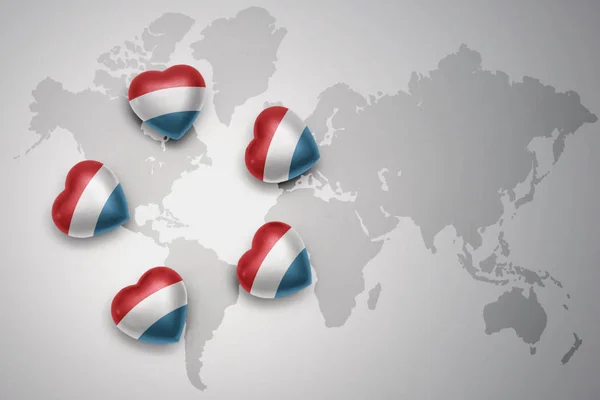 Cinq cœurs avec drapeau national du Luxembourg sur fond de carte du monde . — Photo