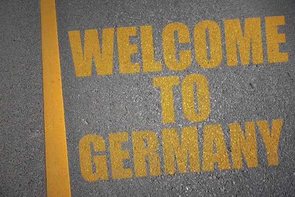 Asphaltstraße mit Text Willkommen in Deutschland nahe der gelben Linie. — Stockfoto