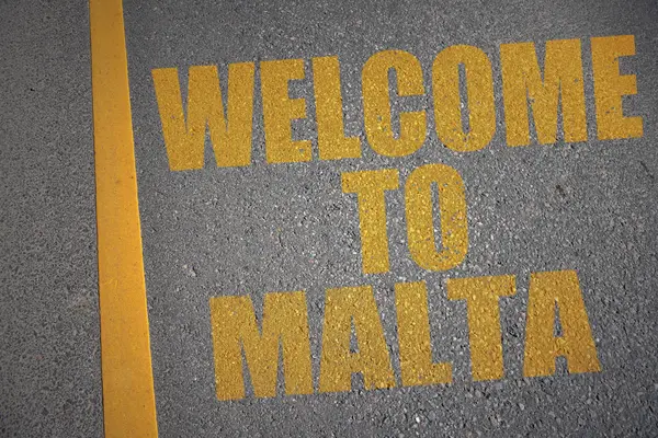Strada asfaltata con testo benvenuto a malta vicino alla linea gialla . — Foto Stock