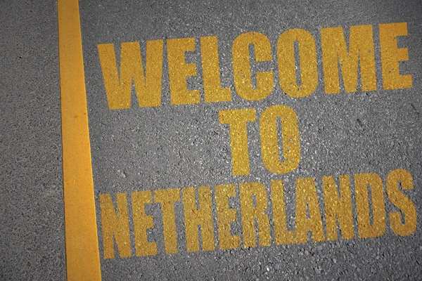 Asfaltweg met de tekst Welkom bij Nederland in de buurt van gele lijn. — Stockfoto