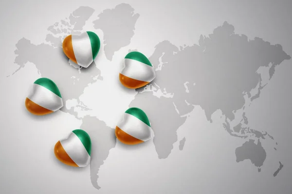 Five hearts with national flag of cote divoire on a world map background. — Stock Photo, Image