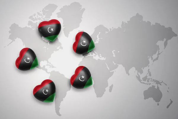 Five hearts with national flag of libya on a world map background. — Stock Photo, Image