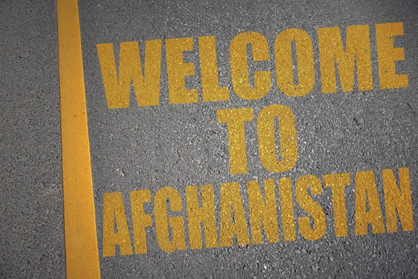 Asfaltvägen med texten Välkommen till afghanistan nära gula linjen. — Stockfoto