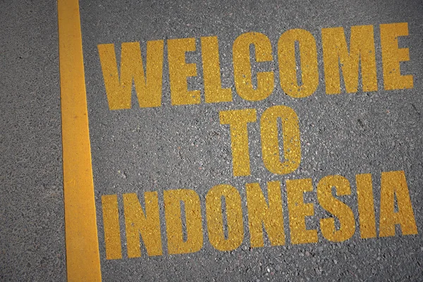 Estrada de asfalto com texto bem-vindo à indonésia perto de linha amarela . — Fotografia de Stock