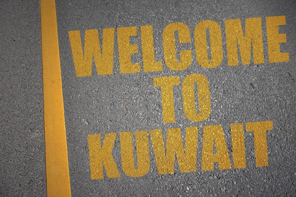 Strada asfaltata con testo benvenuto a Kuwait vicino alla linea gialla . — Foto Stock