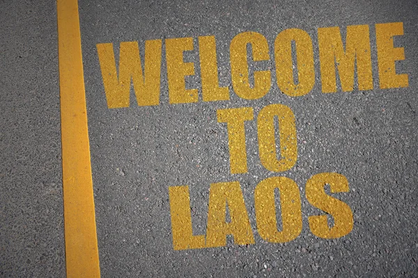 Strada asfaltata con testo benvenuto al laos vicino alla linea gialla . — Foto Stock