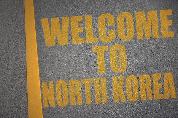 带文本的沥青路欢迎到北朝鲜在黄线附近. — 图库照片