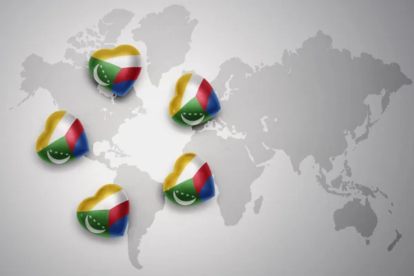 Cinco corazones con bandera nacional de las comoras en un mapa del mundo fondo . — Foto de Stock