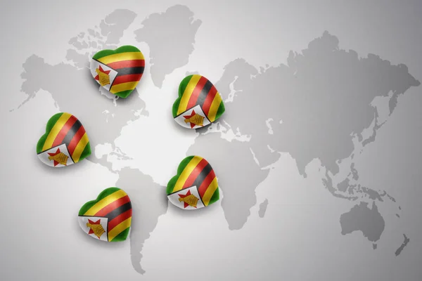 Pięciu serca z flagi narodowej Zimbabwe na tle mapy świata. — Zdjęcie stockowe
