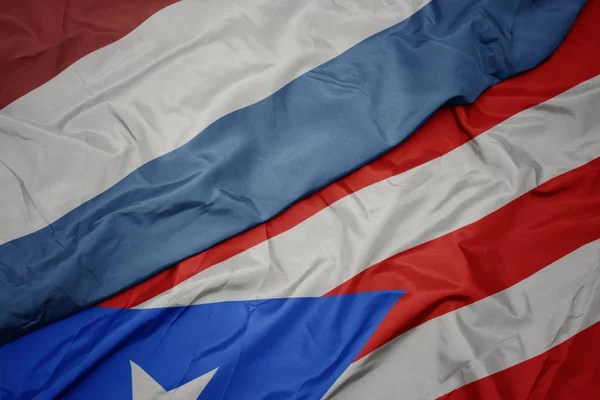Хвилястий барвистий прапор Пуерто-Рико і національний прапор Люксембургу . — стокове фото