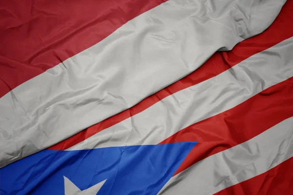 Ondeando colorida bandera de puerto rico y bandera nacional de indonesia . — Foto de Stock