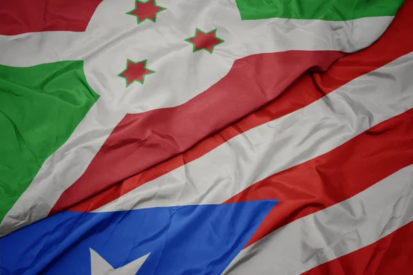 Ondeando colorida bandera de puerto rico y bandera nacional de burundi  . — Foto de Stock