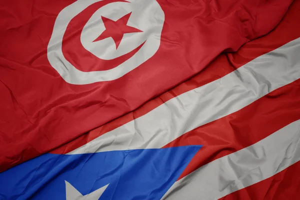 Machanie kolorową flagą puerto rico i flagą narodową Tunezji. — Zdjęcie stockowe