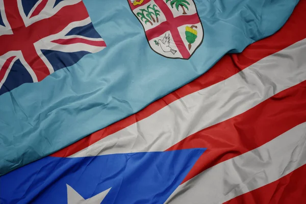 Machanie barwną flagą puerto rico i flagą narodową Fidżi . — Zdjęcie stockowe