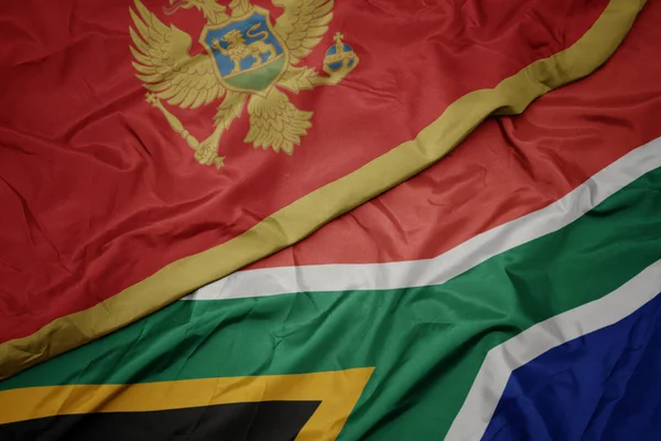 Хвилястий барвистий прапор Південної Африки та національний прапор Чорногорії . — стокове фото