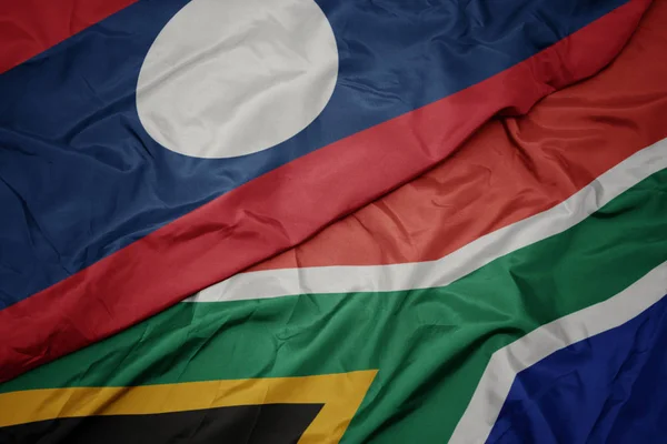 南アフリカのカラフルな旗とラオスの国旗を振って. — ストック写真