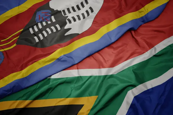Acenando bandeira colorida da África do Sul e bandeira nacional da Suazilândia . — Fotografia de Stock