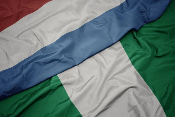 Schwenken bunte Flagge Nigerias und luxemburgische Nationalflagge. — Stockfoto