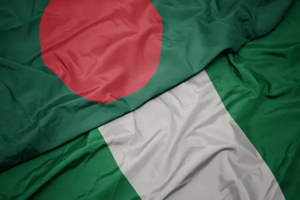 Machanie kolorową flagą Nigerii i flagą narodową Bangladeszu. — Zdjęcie stockowe