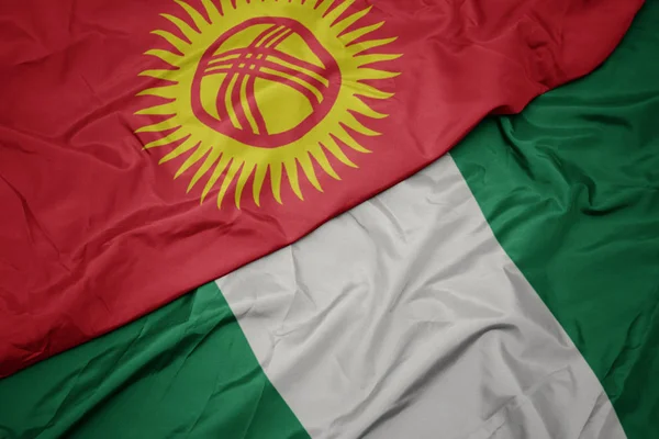 Nijerya 'nın renkli bayrağı ve Kırgızistan' ın ulusal bayrağı sallanıyor. — Stok fotoğraf