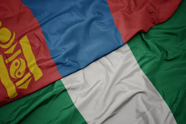 Zwaaiende vlag van nigeria en nationale vlag van mongolie. — Stockfoto