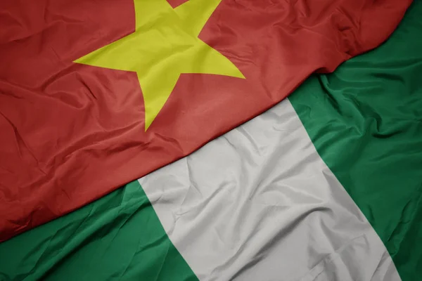 Ondeando colorida bandera de Nigeria y bandera nacional de Vietnam . — Foto de Stock