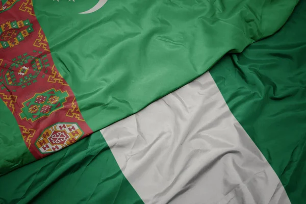 Waving colorful flag of nigeria and national flag of turkmenistan. — Stock Photo, Image