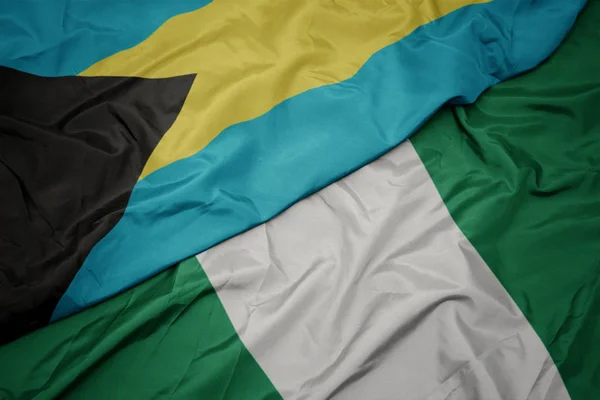 Waving colorful flag of nigeria and national flag of bahamas. — Stock Photo, Image