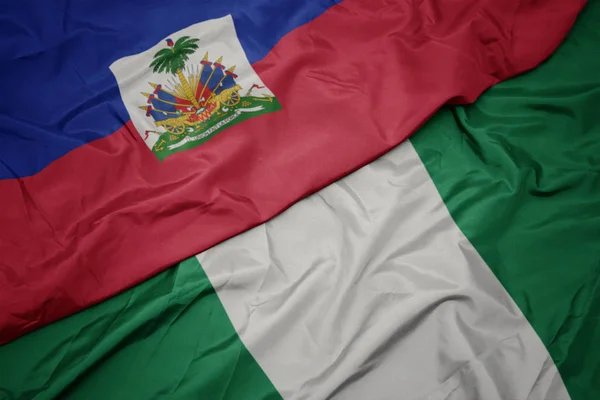 Acenando bandeira colorida da nigéria e bandeira nacional do haiti . — Fotografia de Stock
