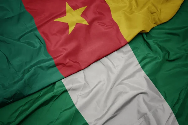 Ondeando colorida bandera de nigeria y bandera nacional de camerún . — Foto de Stock