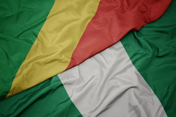 Agitant drapeau coloré de nigeria et drapeau national de la république du congo . — Photo