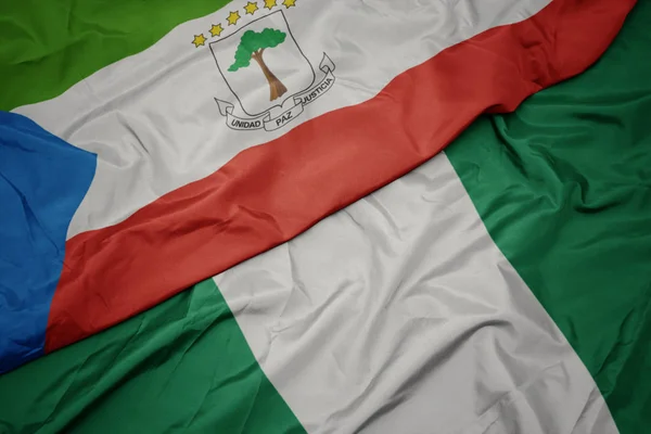 Acenando bandeira colorida da nigéria e bandeira nacional da Guiné Equatorial . — Fotografia de Stock