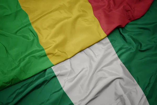 Ondeando colorida bandera de nigeria y bandera nacional de mali . — Foto de Stock