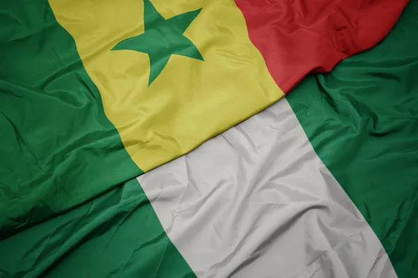 Schwenken bunte Flagge Nigerias und Nationalflagge Senegals. — Stockfoto