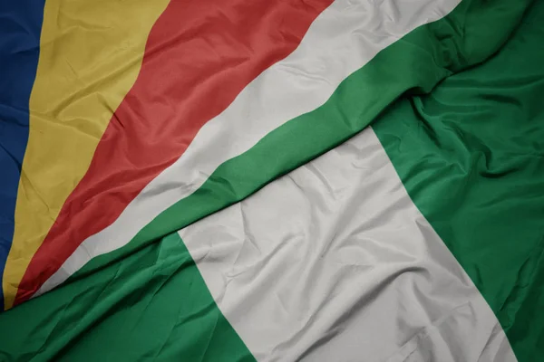 Schwenken bunte Flagge Nigerias und Nationalflagge der Seychellen. — Stockfoto