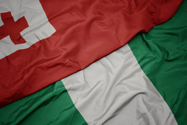 Nijerya 'nın renkli bayrağı ve Tonga' nın ulusal bayrağı sallanıyor. . — Stok fotoğraf