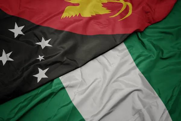 Ondeando colorida bandera de Nigeria y bandera nacional de Papúa Nueva Guinea  . —  Fotos de Stock