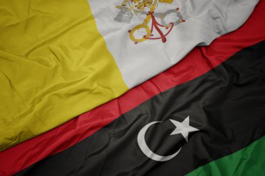 Libya 'nın renkli bayrağı ve Vatikan' ın ulusal bayrağı sallanıyor.