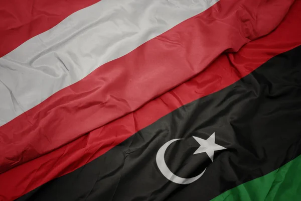 Waving colorful flag of libya and national flag of austria. — Stock Photo, Image