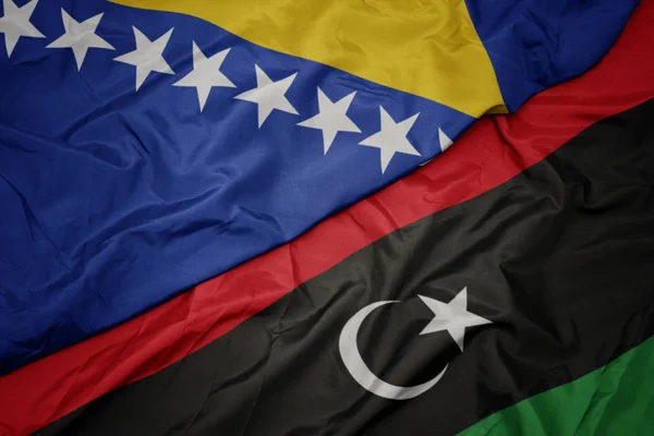 Ondeando colorida bandera de libya y bandera nacional de bosnia y Herzegovina . — Foto de Stock