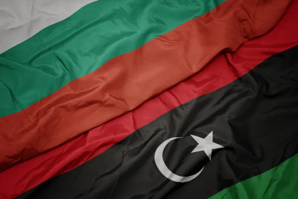 Waving colorful flag of libya and national flag of bulgaria. — Stock Photo, Image