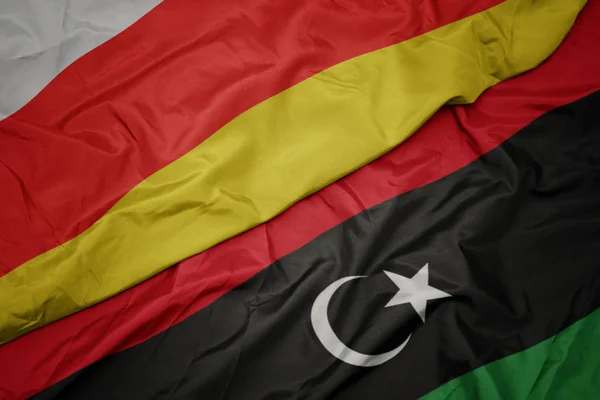 Ondeando colorida bandera de libya y bandera nacional de Osetia del Sur . — Foto de Stock