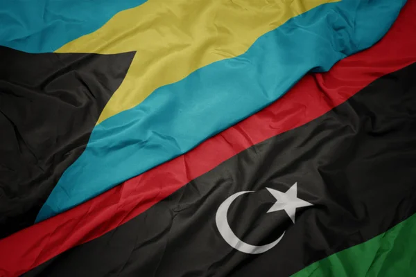 Ondeando colorida bandera de libya y bandera nacional de Bahamas . — Foto de Stock