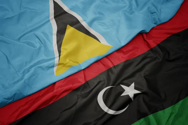 Ondeando colorida bandera de libya y bandera nacional de santa lucia . — Foto de Stock