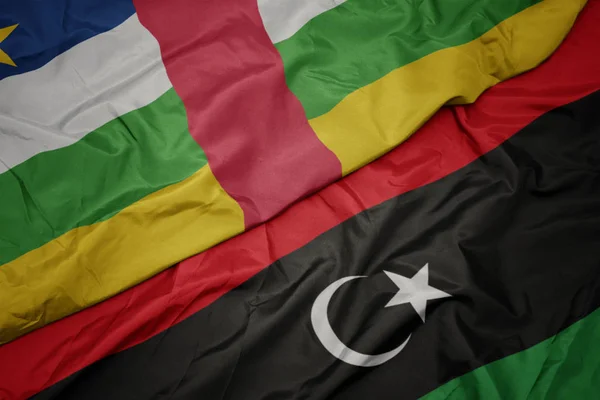 Ondeando colorida bandera de libya y bandera nacional de la República Centroafricana . — Foto de Stock