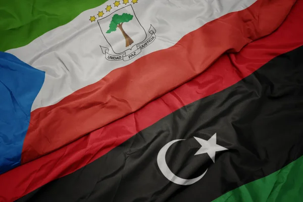 Acenando bandeira colorida da Líbia e bandeira nacional da Guiné Equatorial . — Fotografia de Stock