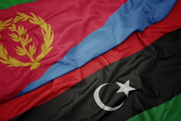 Acenando bandeira colorida da Líbia e bandeira nacional da eritreia . — Fotografia de Stock